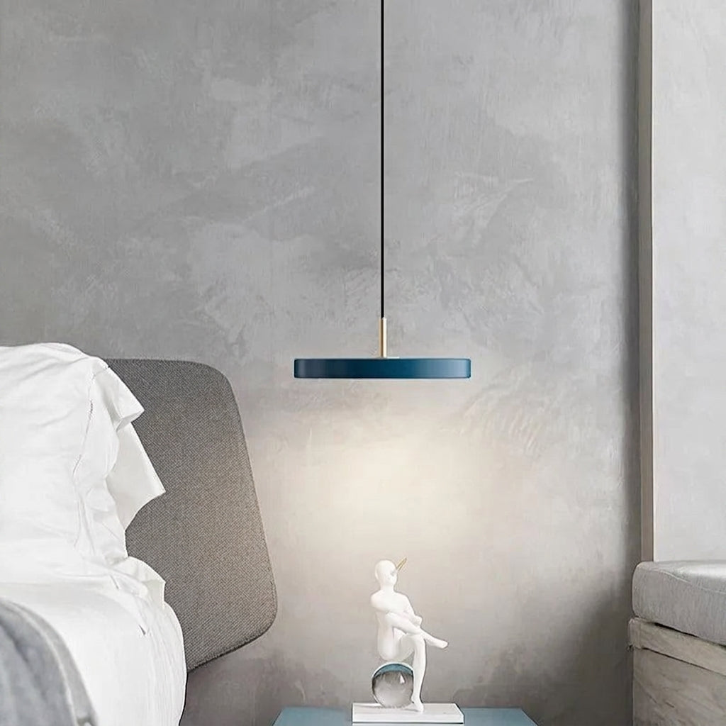 Blue Scandinavian disc pendant light over a bedside table