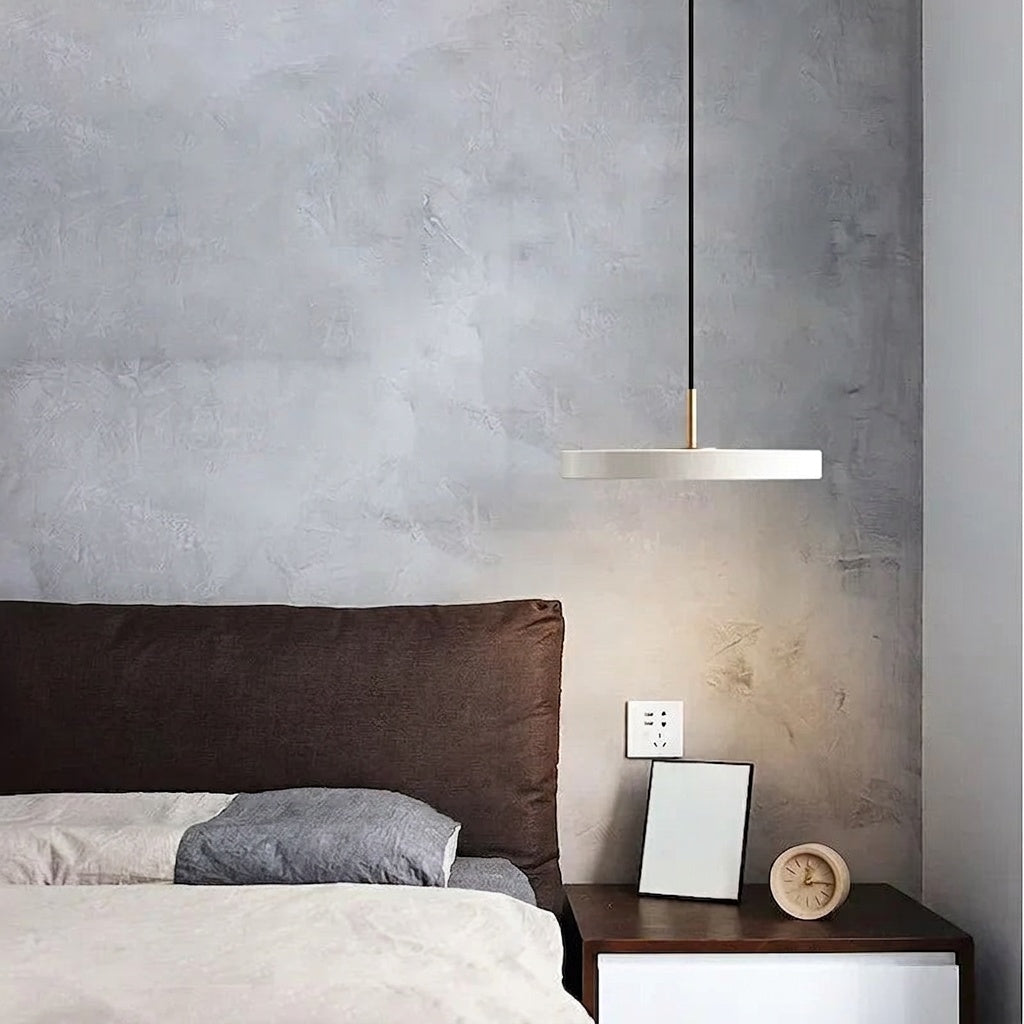 White Scandinavian disc pendant light over a bed